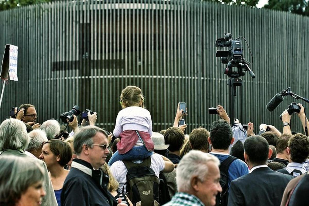 a crowd of people standing in front of a wall