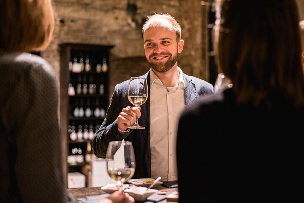 a man holding a glass of wine at a table