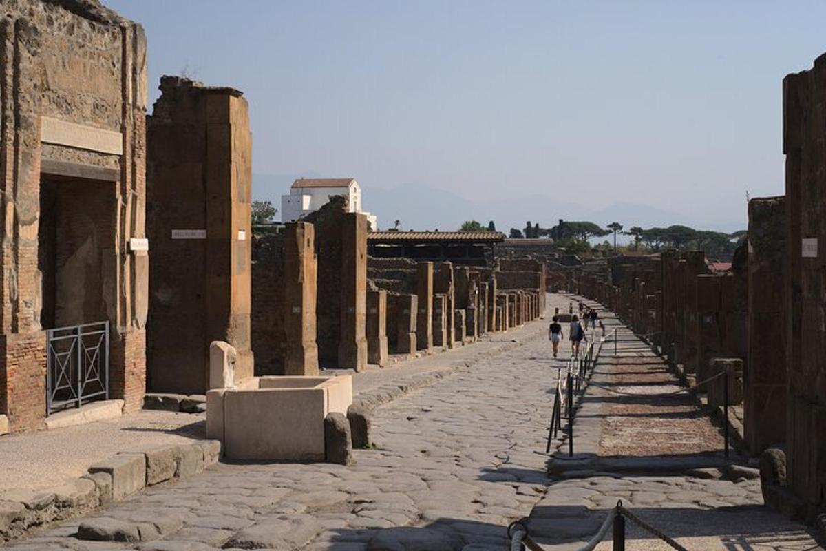 Dos personas caminan por una calle en ruinas.