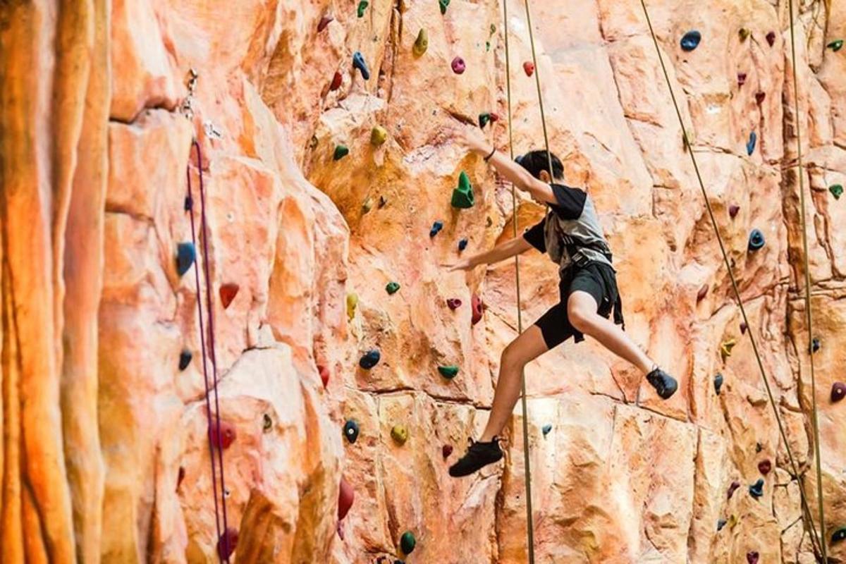a man is climbing a rock climbing wall