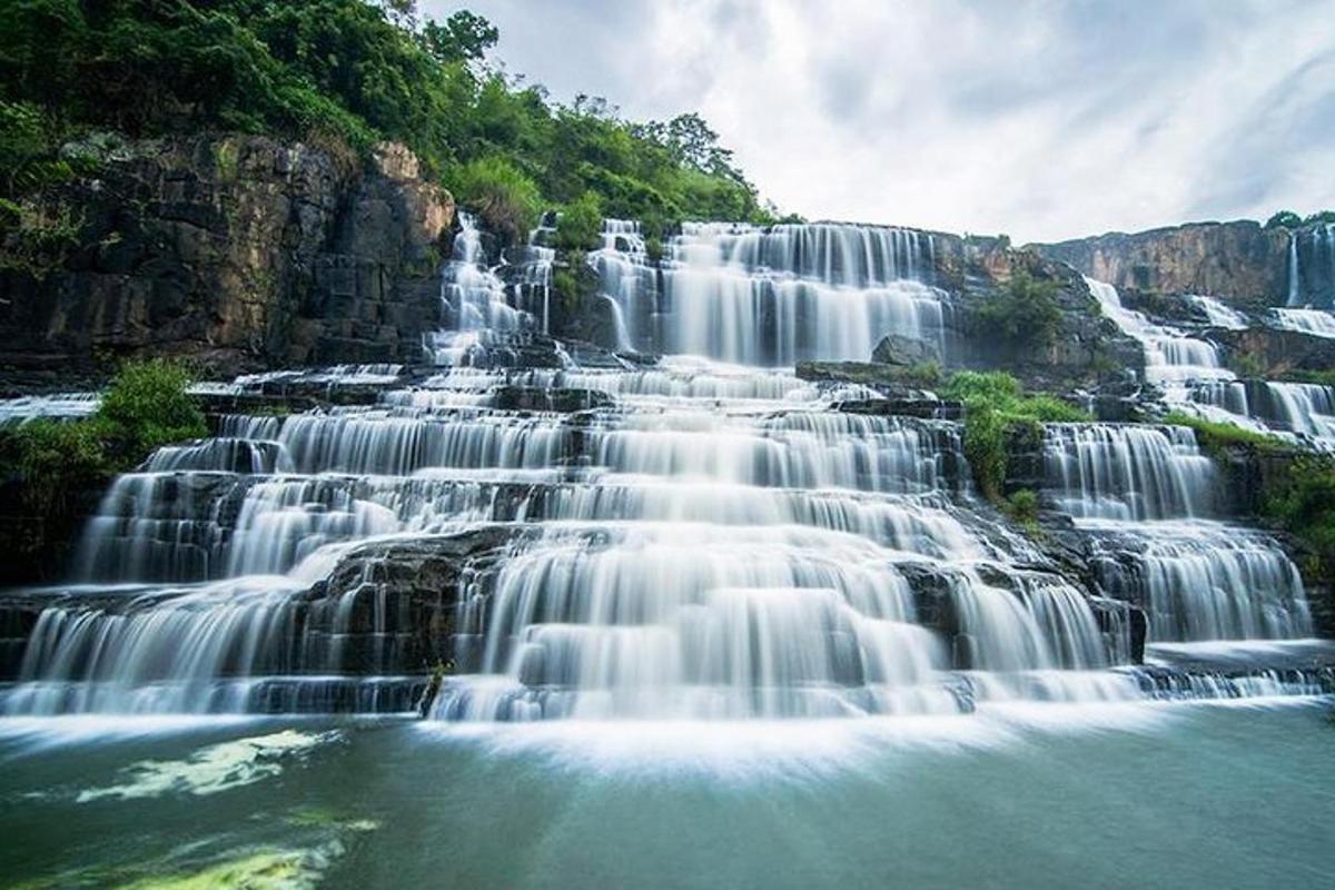 a large waterfall with water falling into a river