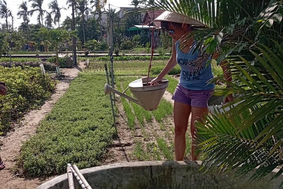 một người phụ nữ đang cầm một cái xô trong vườn