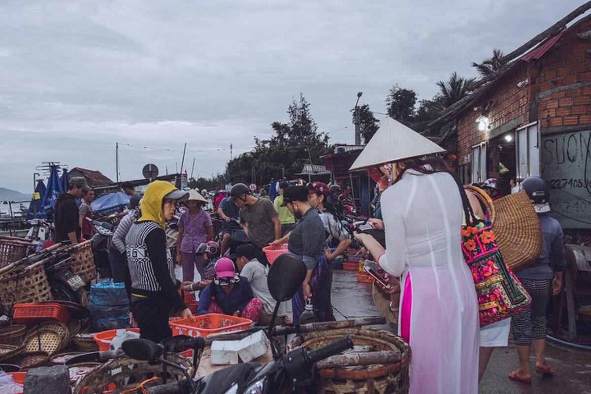 một đám đông người đứng quanh một khu chợ