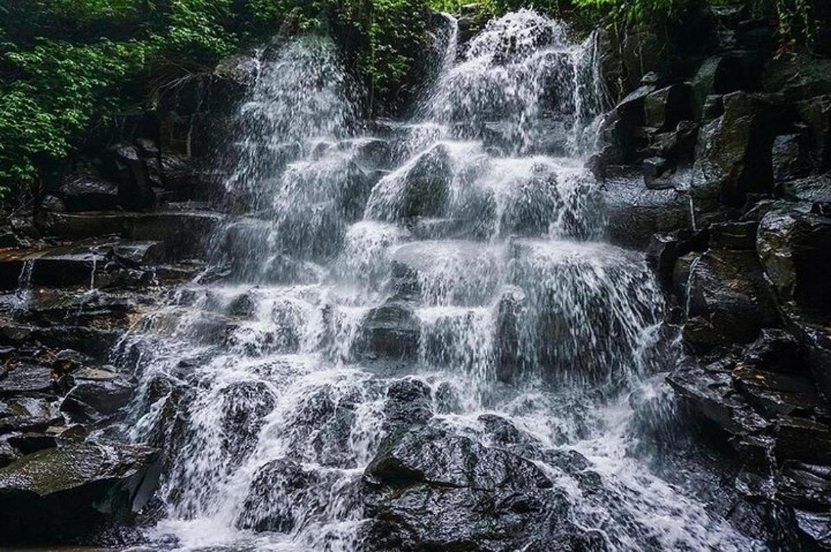 a waterfall on the side of a river with rocks