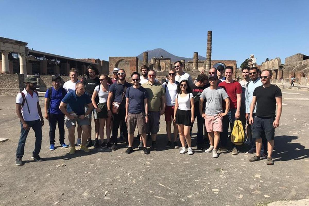 um grupo de pessoas posando para uma foto em frente a um prédio