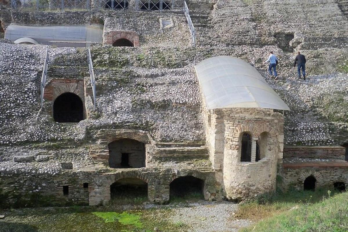 dues persones dempeus davant d'un edifici de pedra