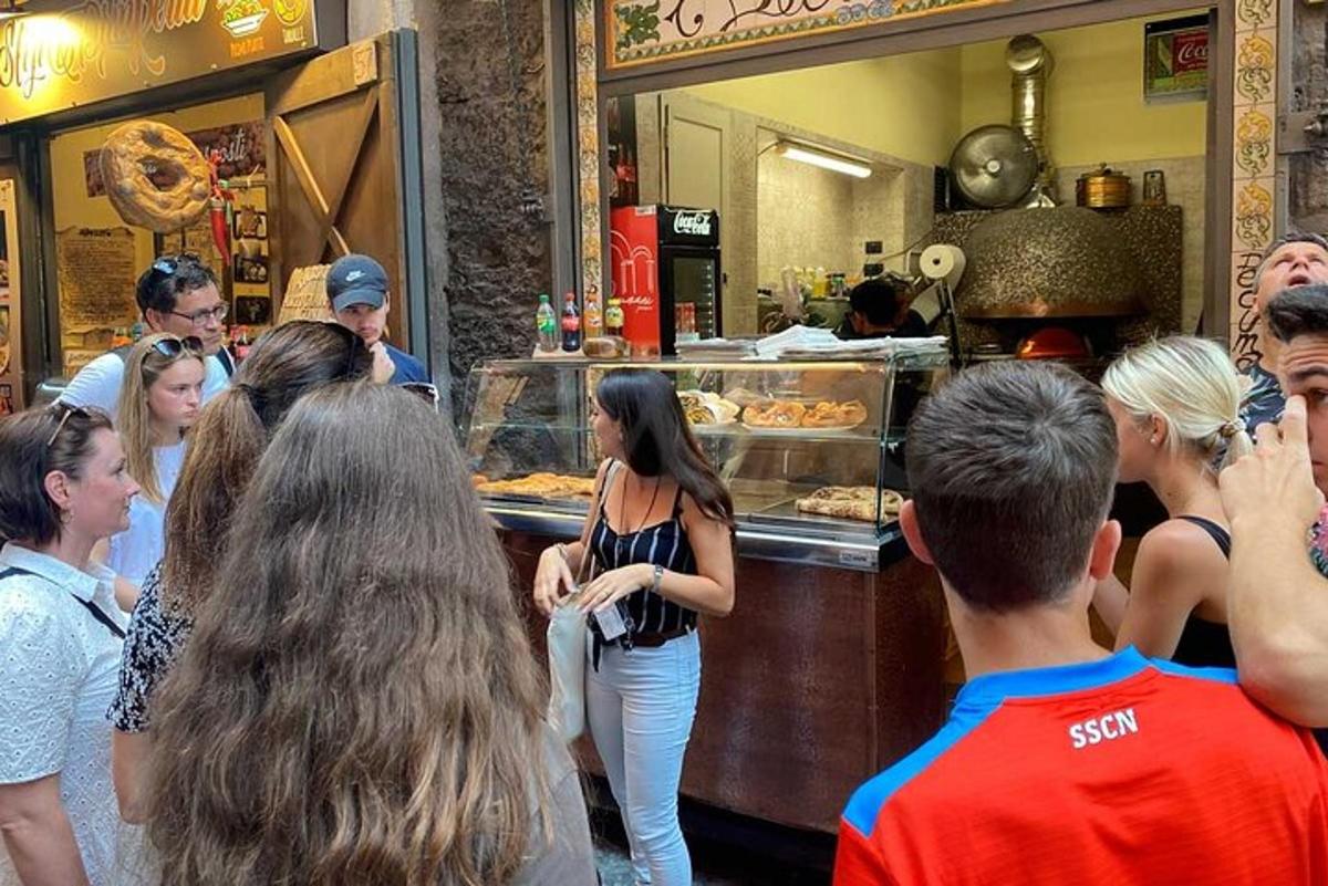 un grup de oameni care stăteau în fața unei pizzerii