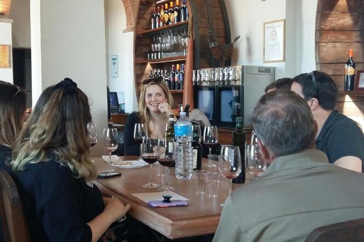 un gruppo di persone sedute attorno a un tavolo con bicchieri di vino