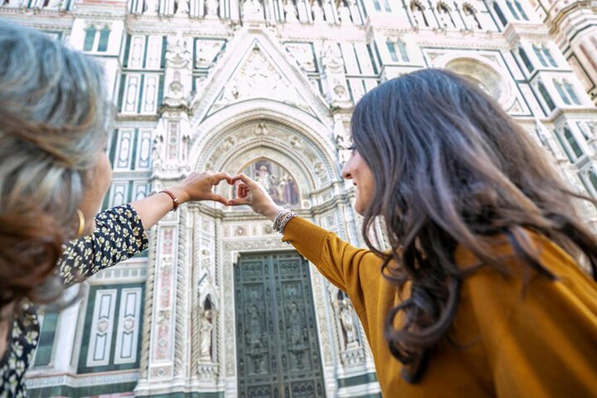 two women making a heart gesture in front of a building
