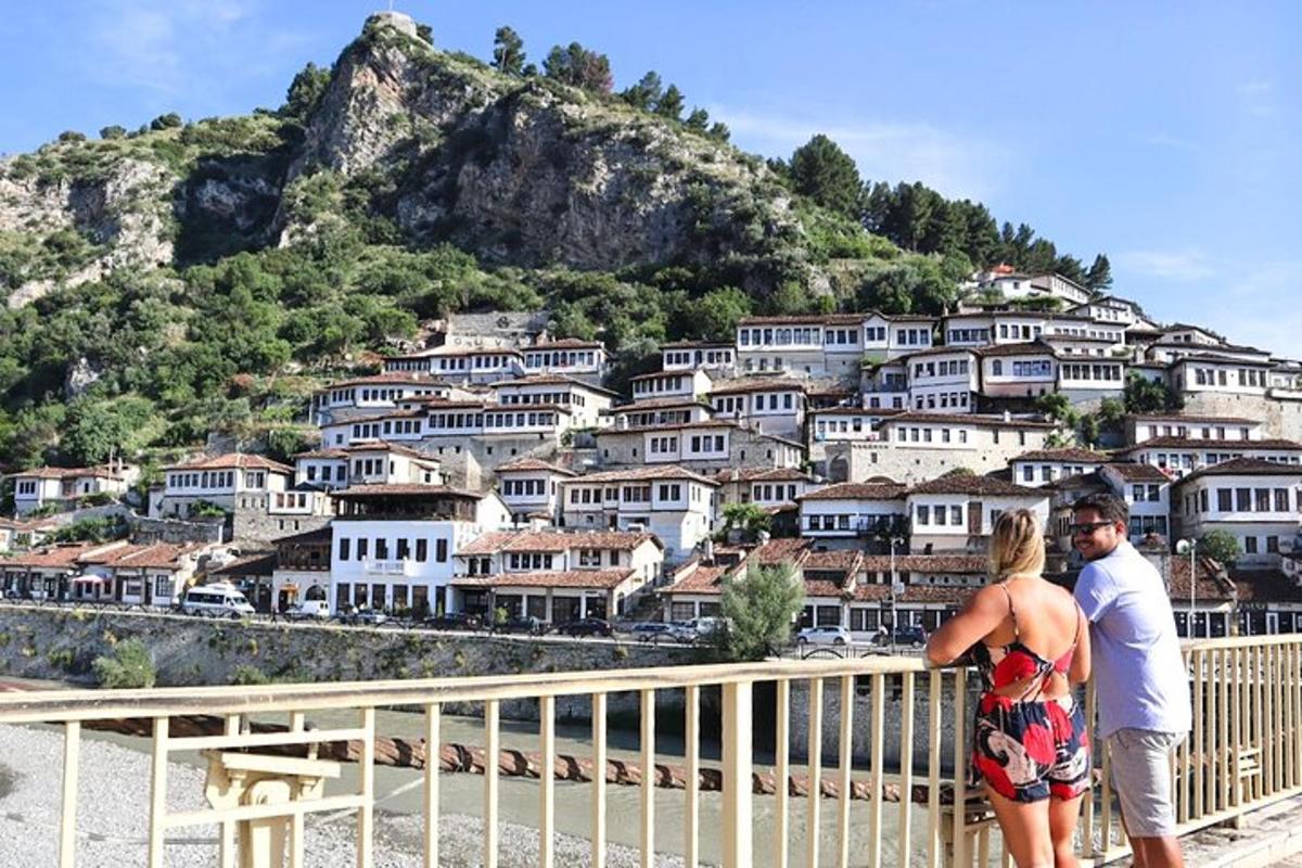 Ένας άντρας και μια γυναίκα στέκονται σε μια γέφυρα κοιτάζοντας ένα βουνό