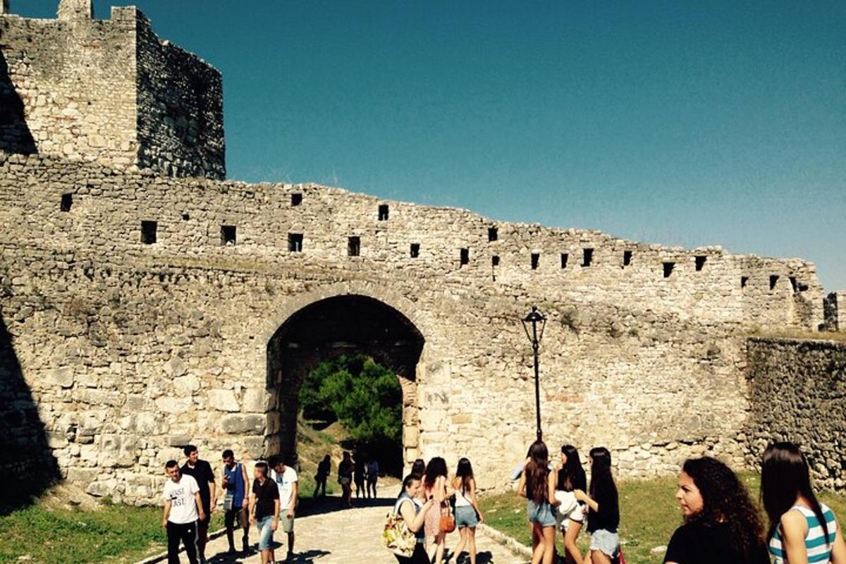 μια ομάδα ανθρώπων που περπατούν μπροστά από ένα κάστρο