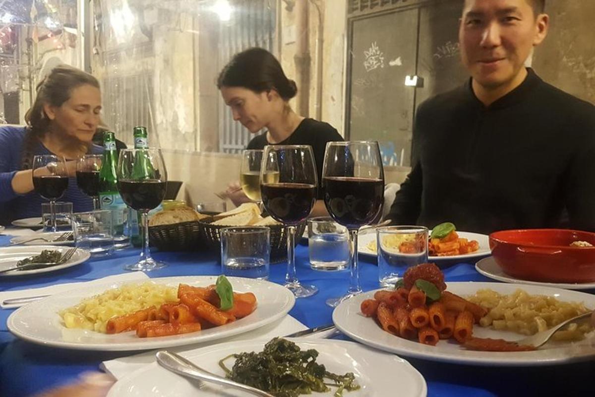 grupp inimesi istub laua taga toidutaldrikutega