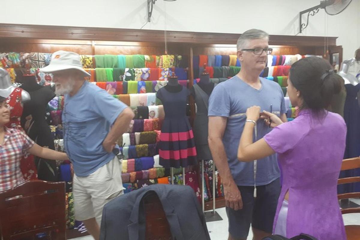 Δύο άνδρες και μια γυναίκα που στέκονται σε ένα κατάστημα ρούχων
