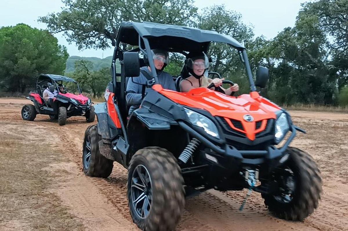 dues persones que viatgen en un quad per una carretera de terra
