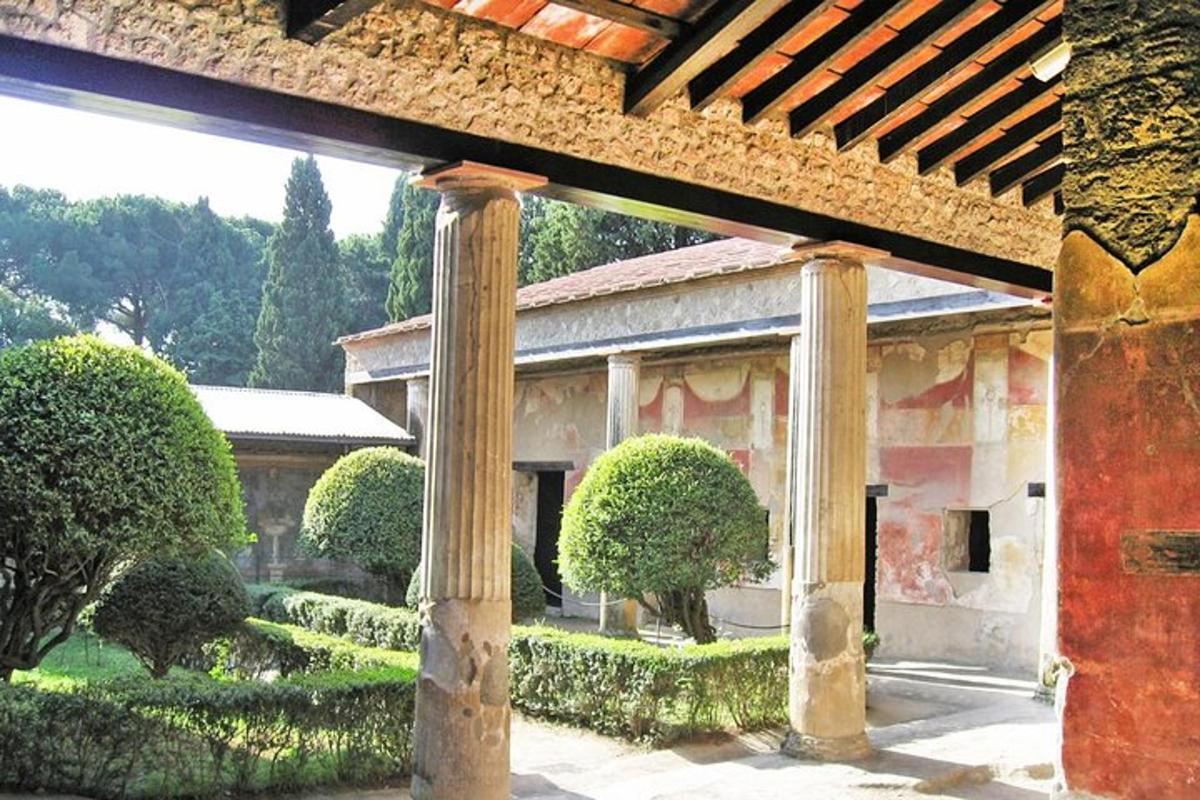 o vedere exterioară a unei clădiri cu coloane și tufișuri