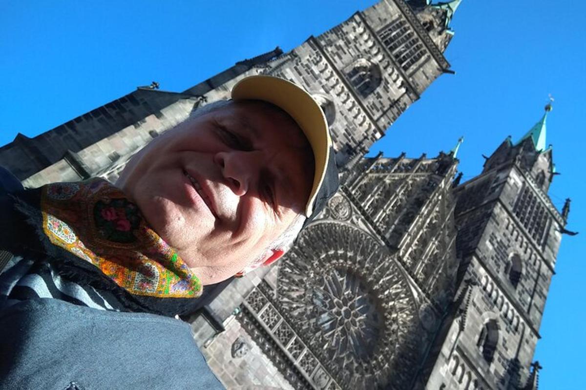 muž v klobouku před hodinovou věží