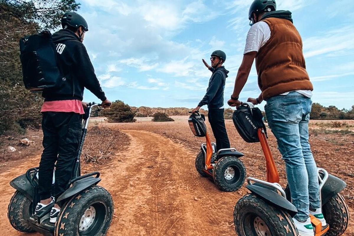 tre persone sono in piedi su scooter su una strada sterrata