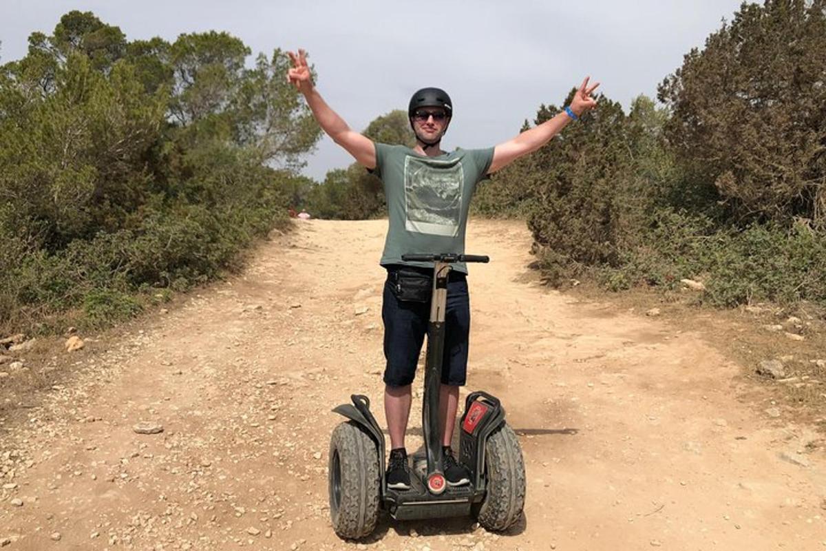 un uomo che guida un segway su una strada sterrata