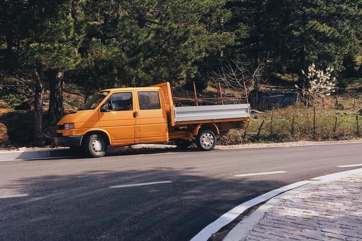 oranžový nákladní vůz zaparkovaný na kraji silnice