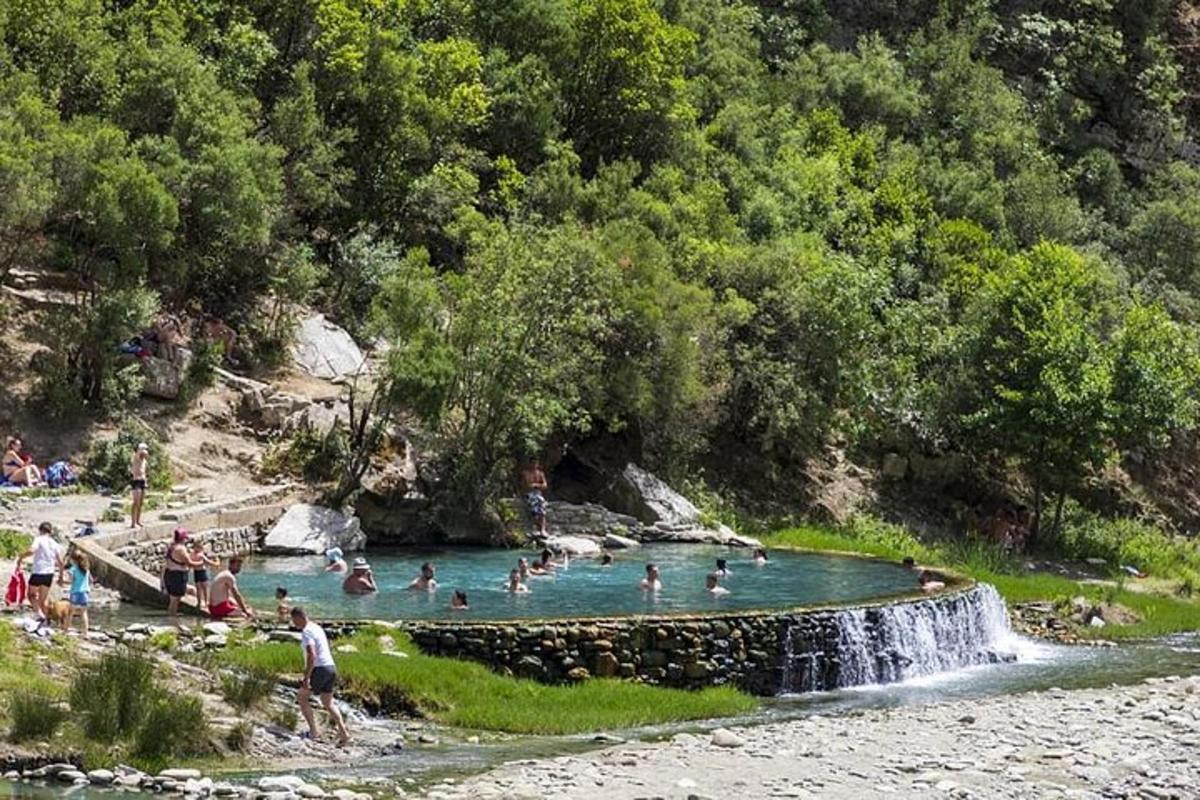 sekumpulan orang di kolam renang dengan air terjun