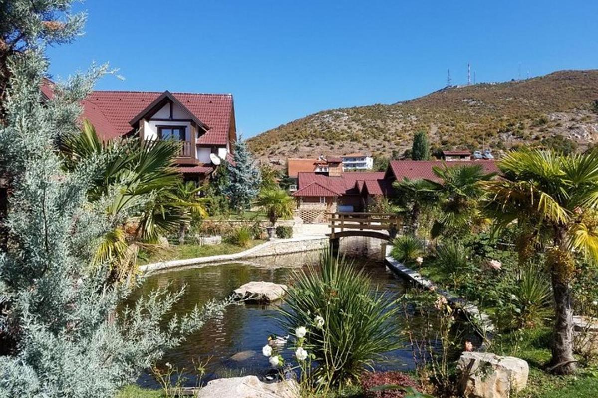 una casa con uno stagno di fronte a una montagna