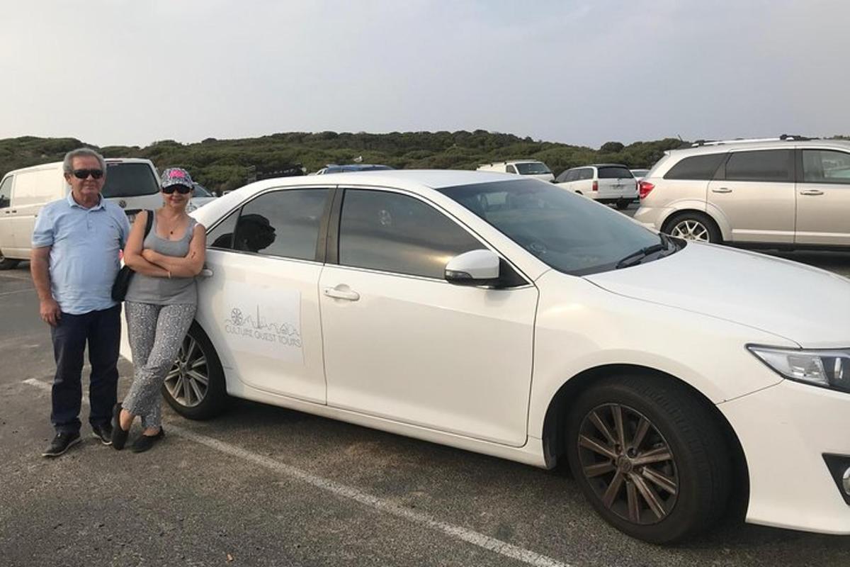 白い車の隣に立っている男性と女性