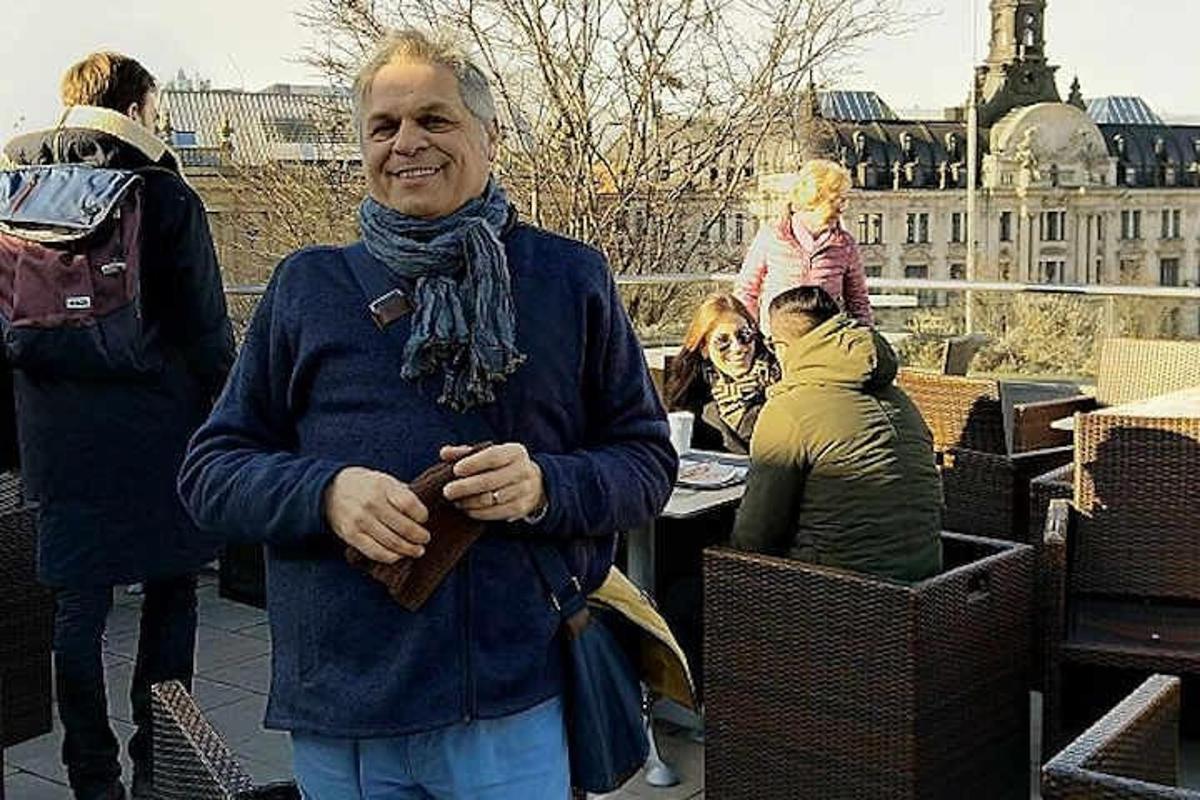 um homem usando um cachecol em pé ao lado de um grupo de pessoas