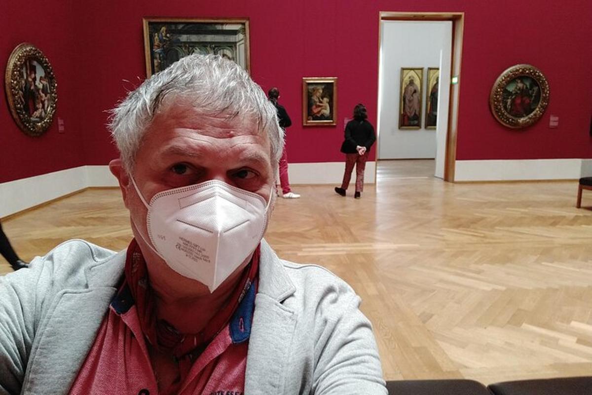 Ένας άντρας με μάσκα στο πρόσωπό του σε ένα μουσείο