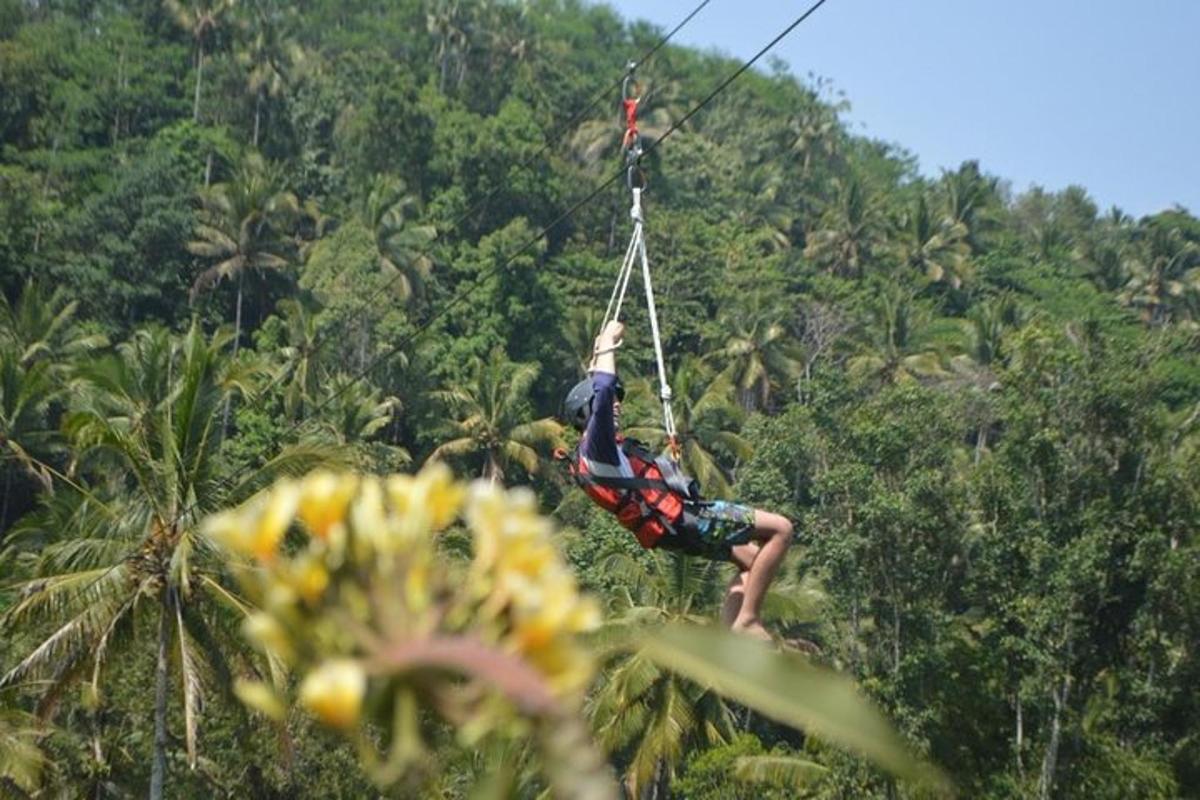muž visící na zip line v džungli