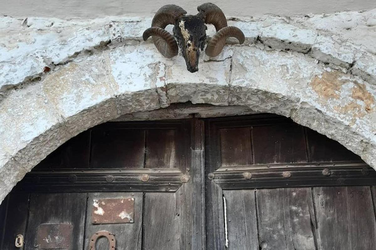 een gebouw met een deur met een geitenkop erboven