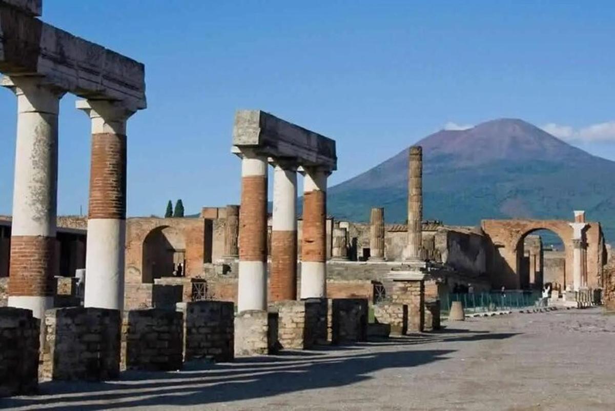 antiche rovine con colonne di fronte a una montagna