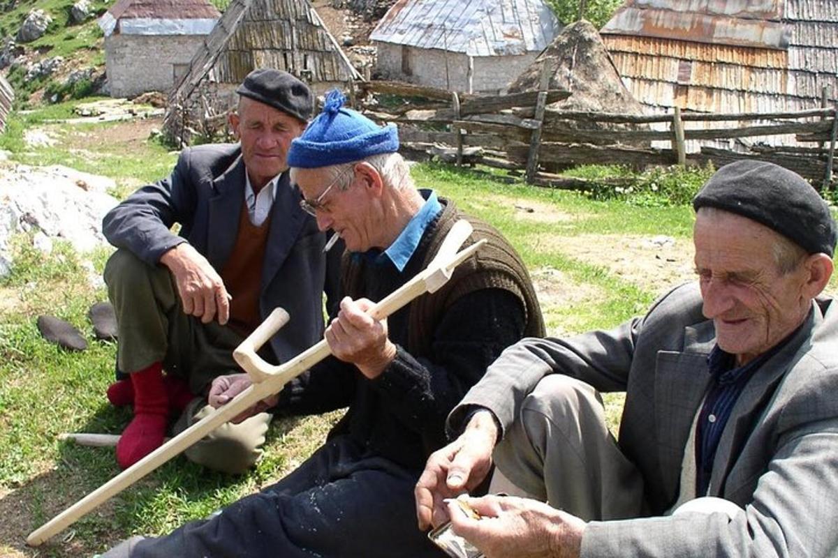 Un grupo de tres hombres sentados en el césped