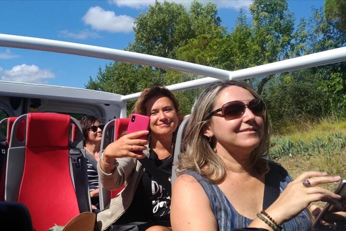 deux femmes assises dans un bus prenant une photo avec un téléphone portable