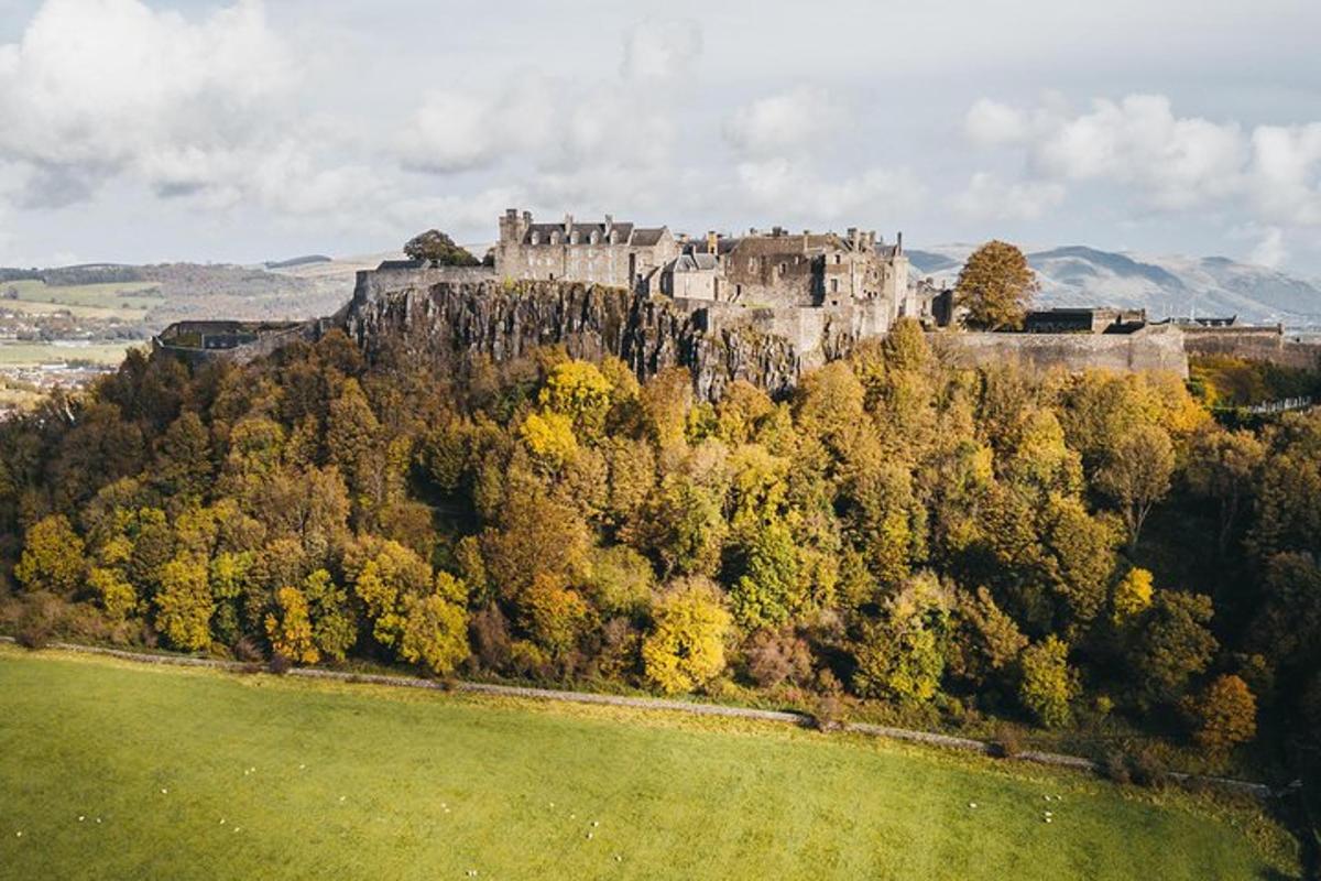 an old castle on top of a hill with trees