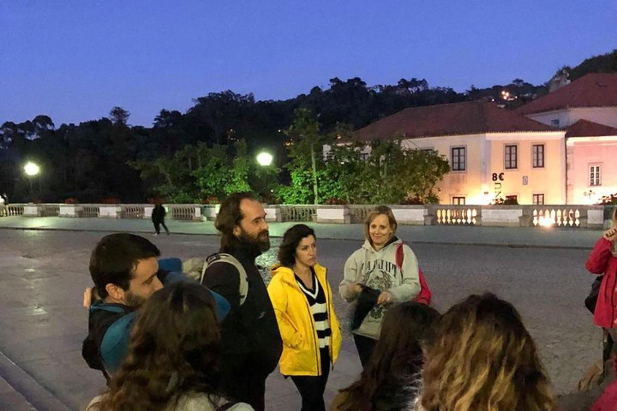 skupina lidí stojících v noci na ulici