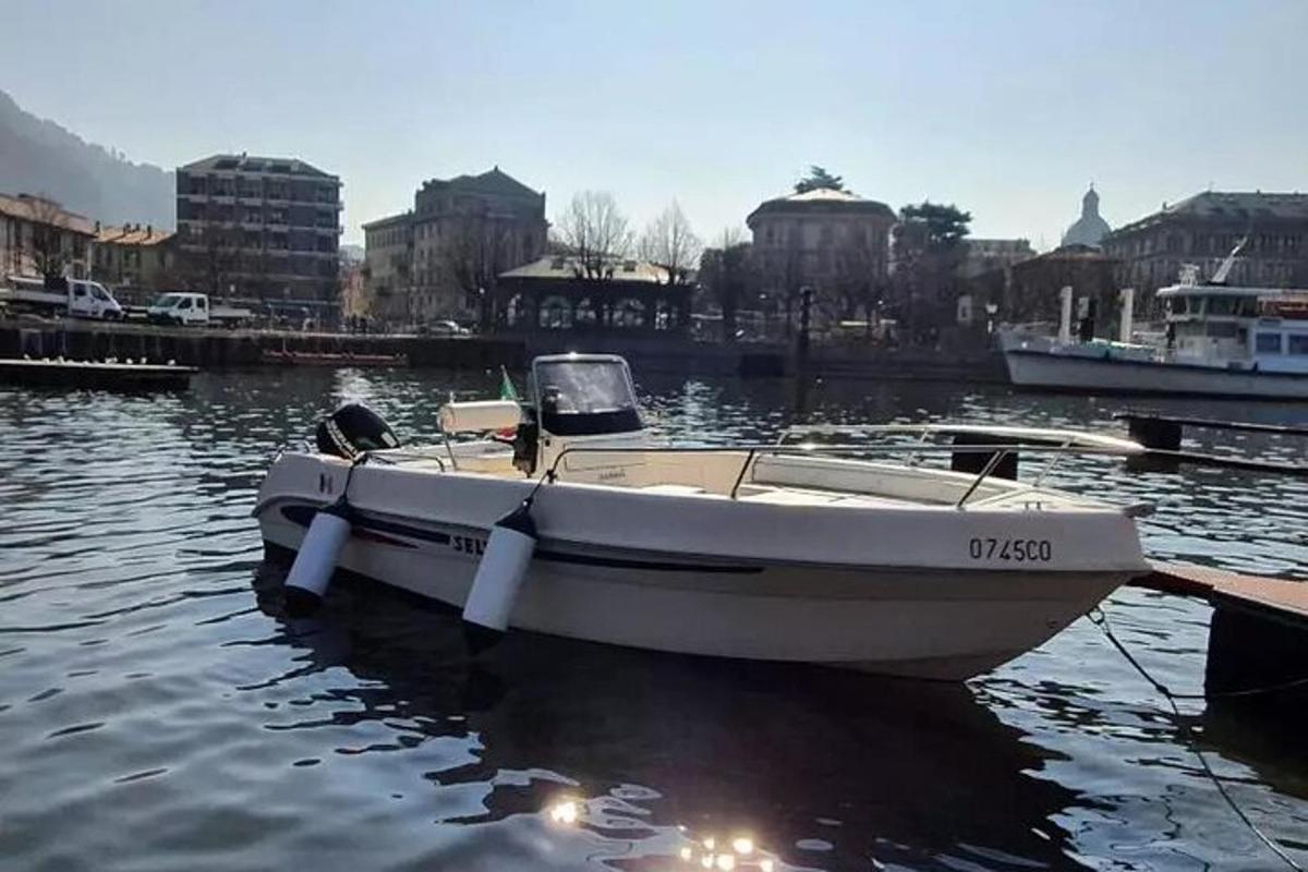 una barca bianca legata a un molo in acqua