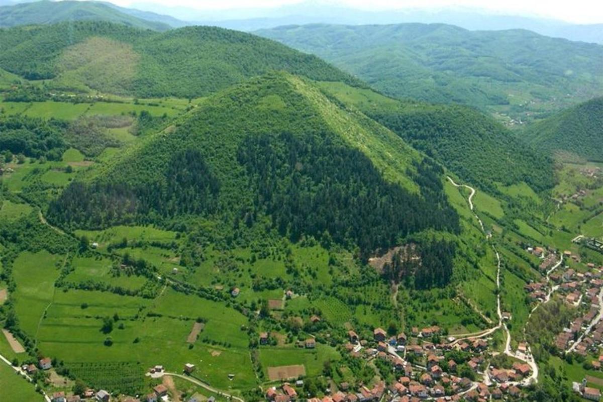 o vedere aeriană a unui deal verde cu case și copaci