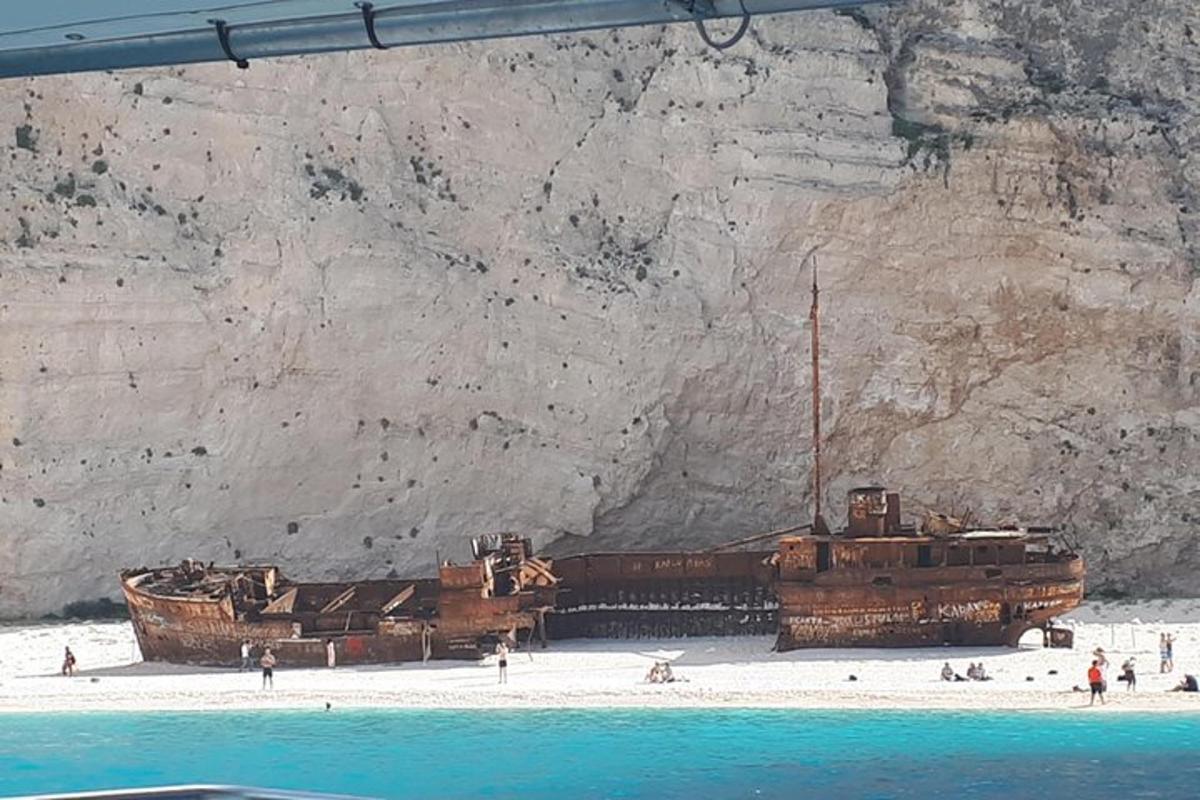 due vecchie navi sedute sulla spiaggia accanto a una montagna