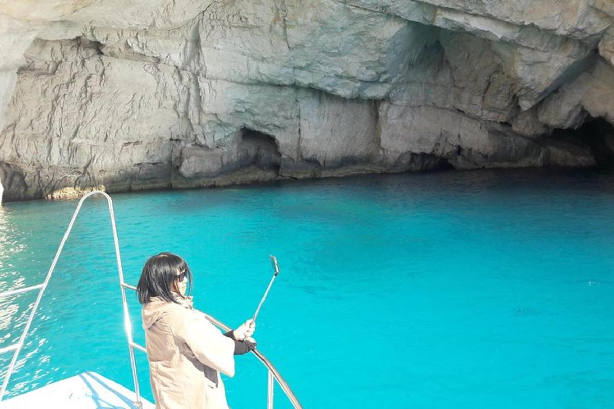 una donna sta remando una barca davanti a una grotta