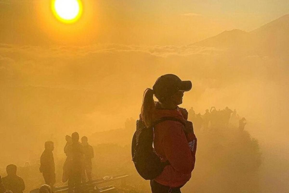 Una persona con una mochila de pie en un campo brumoso