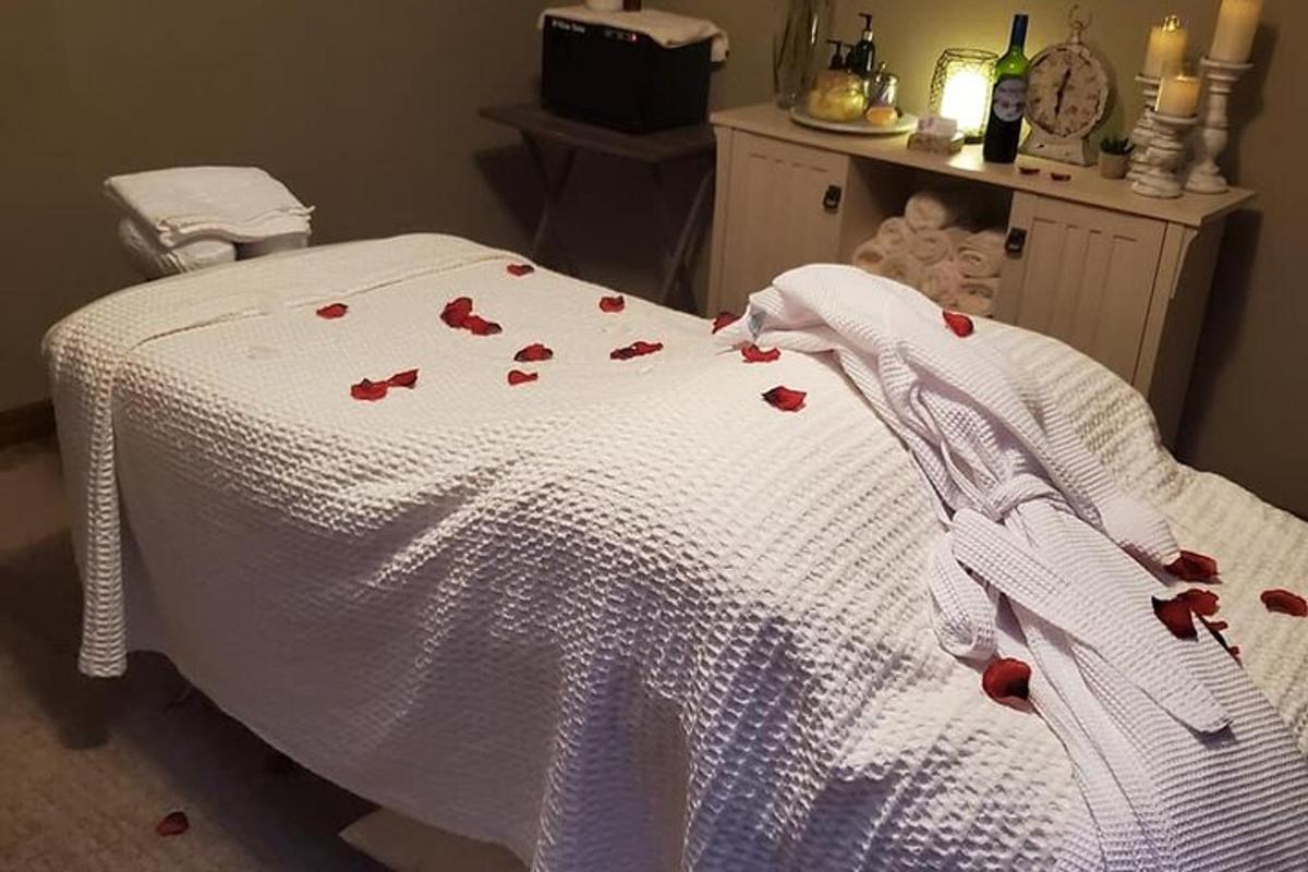 một chiếc giường có hoa hồng trên đó với một chiếc chăn trắng