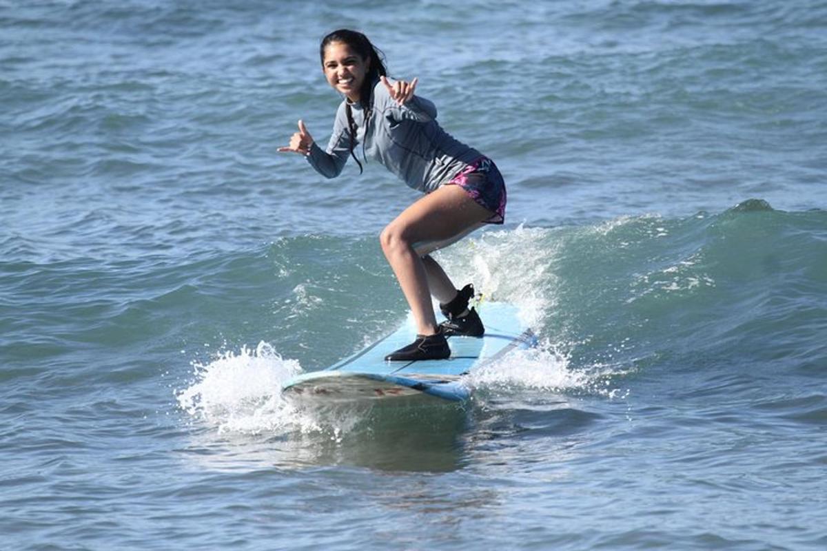 Una niña montando una ola en una tabla de surf en el océano