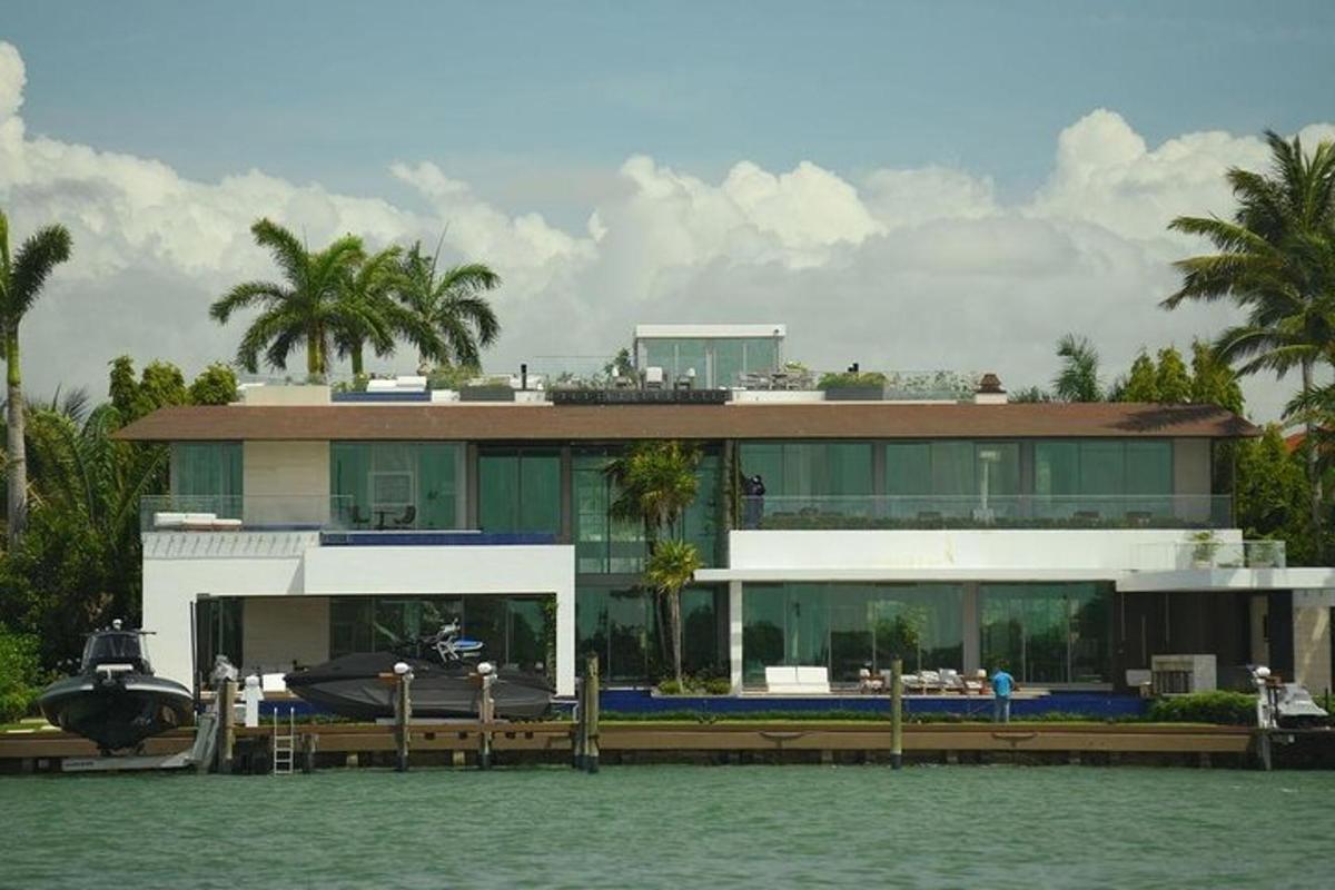 Una casa sobre el agua con un barco delante de ella.