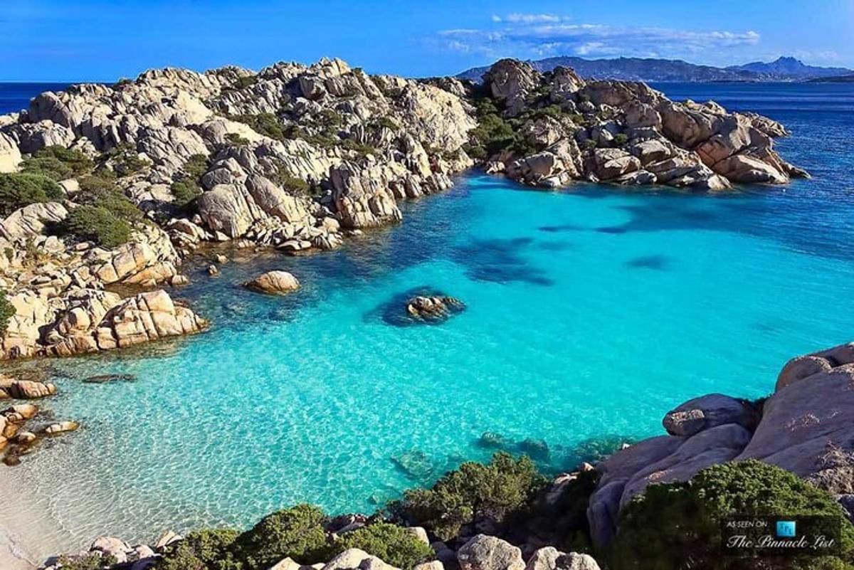 o întindere mare de apă cu stânci și o plajă