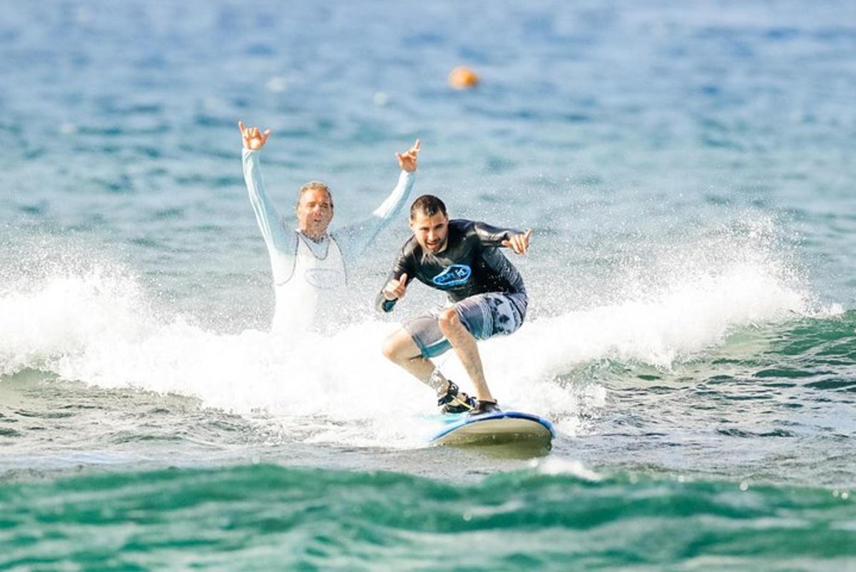 dva lidé jedou na vlně na surfovém prkně v oceánu