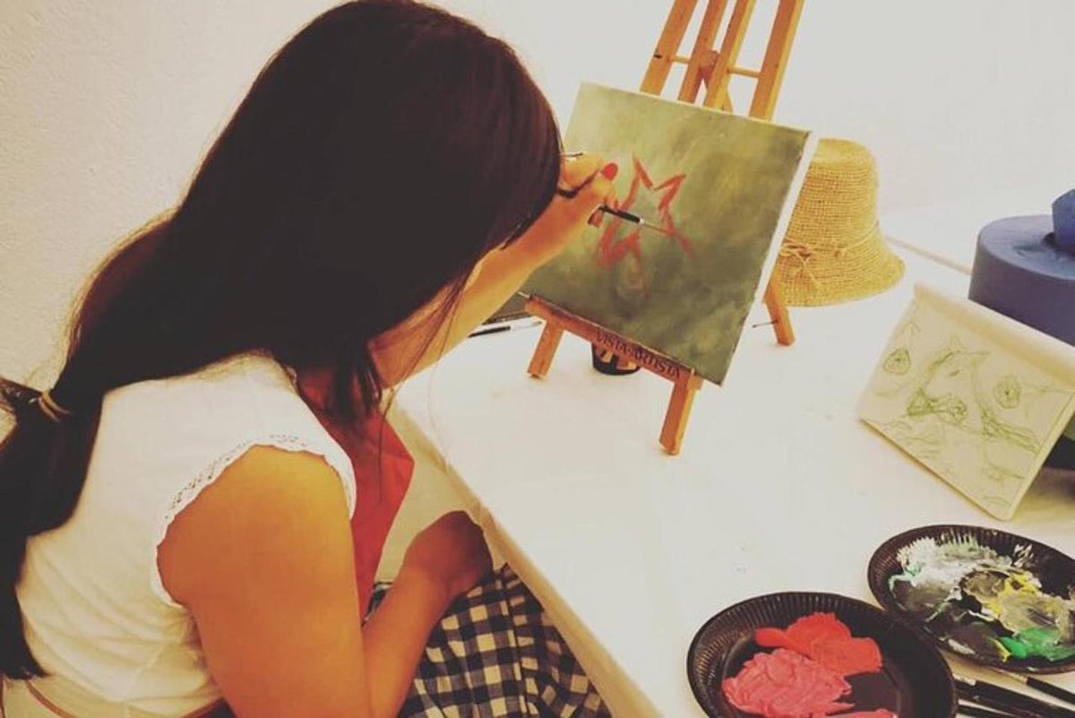 una donna sta dipingendo un quadro su una tela