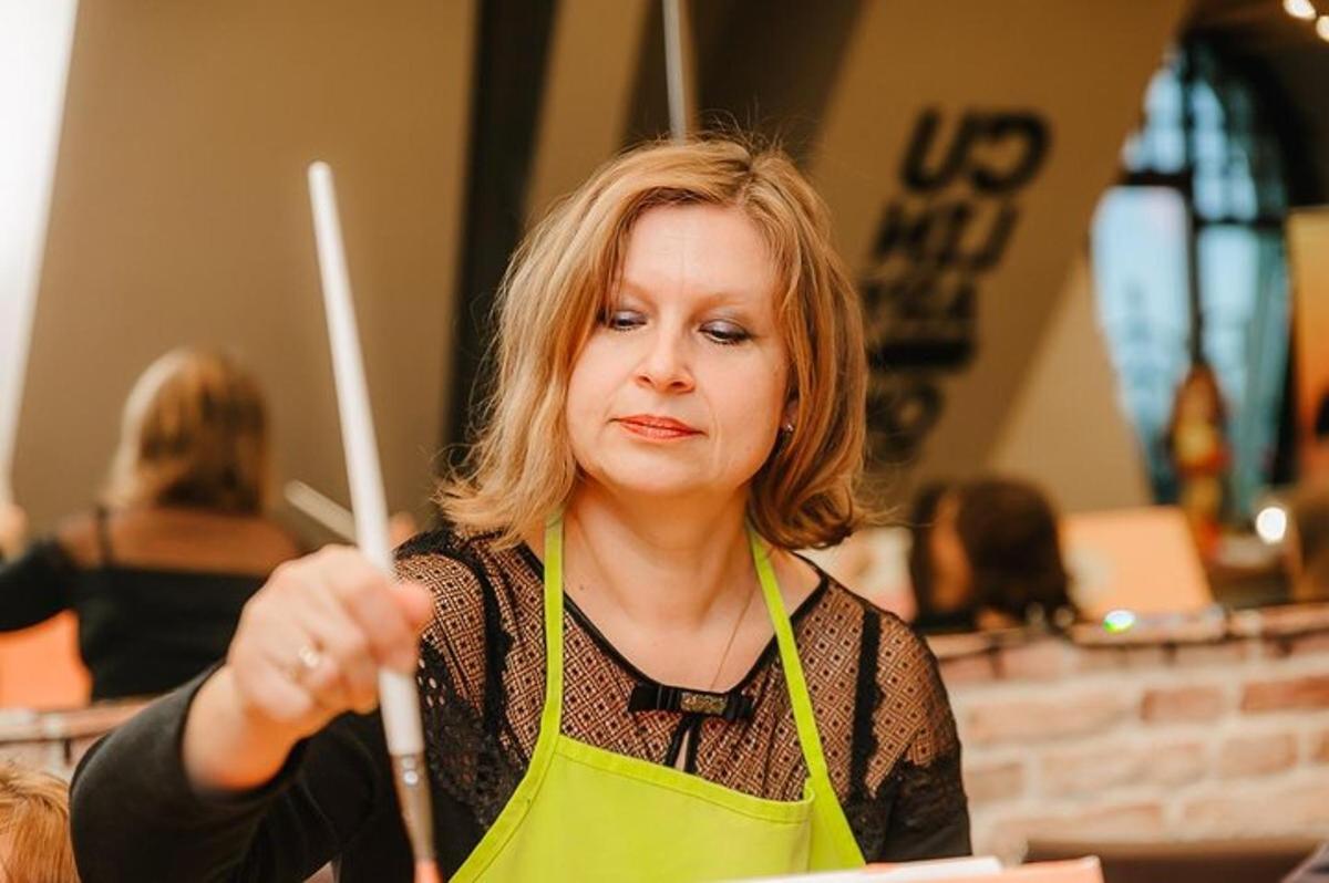 una donna con un grembiule che tiene in mano due bacchette