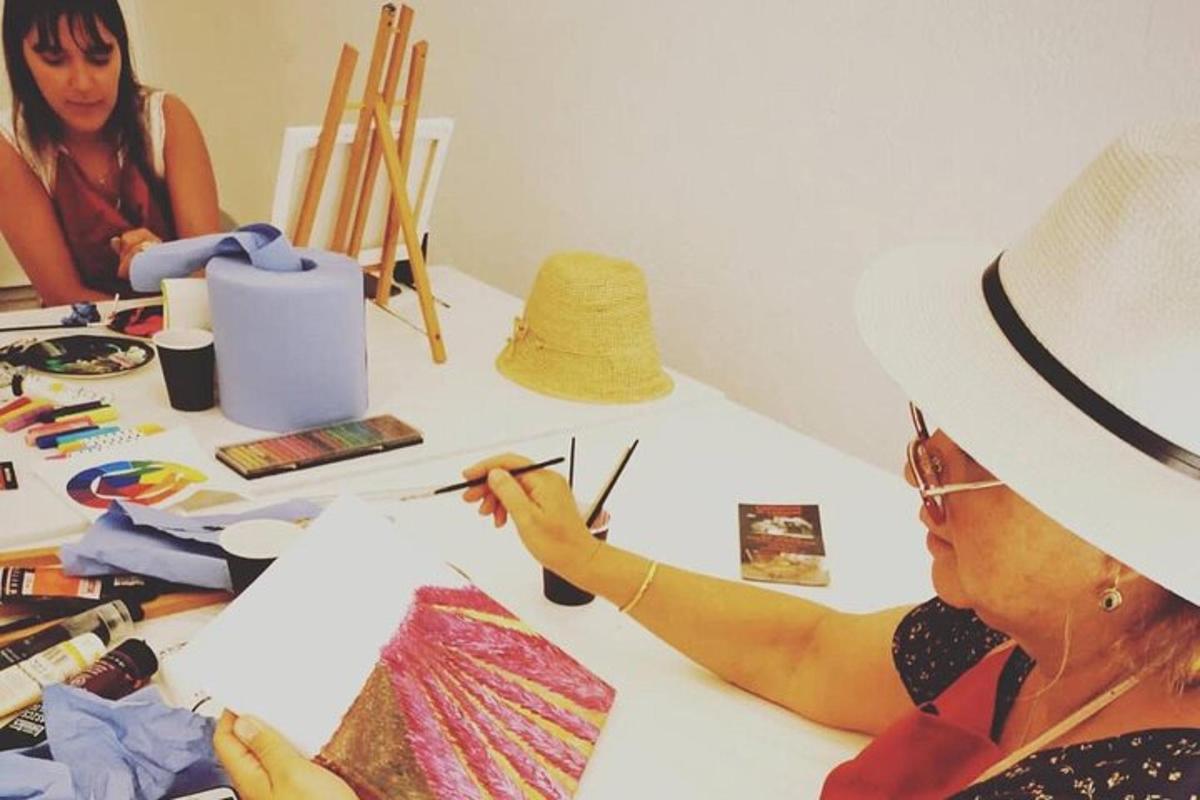 una donna con un cappello sta dipingendo un aquilone
