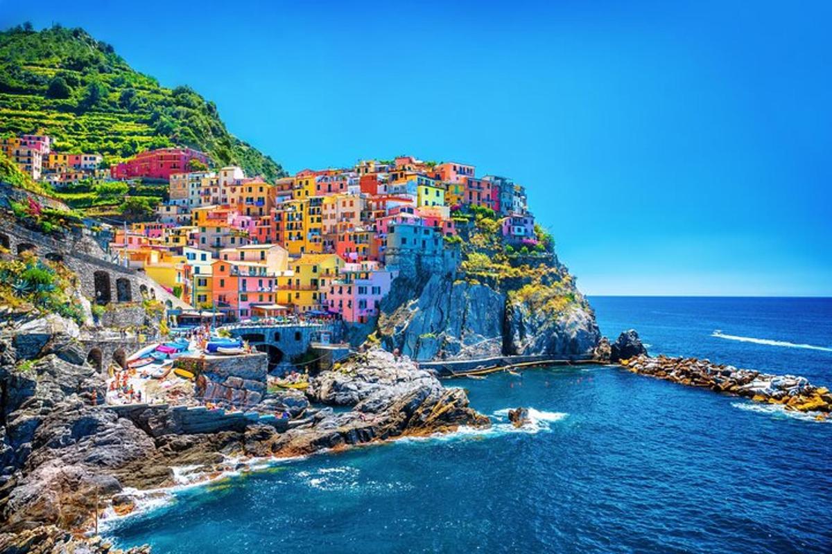 a group of colorful houses on a cliff next to the ocean