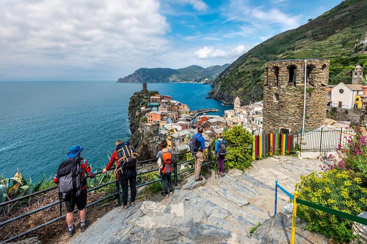 a group of people walking on a cliff near the ocean